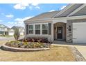 Charming home with a manicured lawn and colorful flower bed, complete with a welcoming front entrance at 11 S Great White Way, Clayton, NC 27527