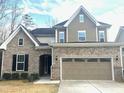 Attractive two-story home with stone facade, arched entryway, and two-car garage at 137 Fawnwood Acres Dr, Apex, NC 27539