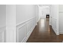 Bright hallway featuring hardwood floors, white wainscoting, and an open view to the living room at 137 Fawnwood Acres Dr, Apex, NC 27539