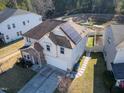 Aerial view of home with solar panels, manicured lawn, and a walkway to a fenced area behind the home at 138 Daneborg Rd, Durham, NC 27703