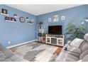 Cozy living room with blue walls, gray sofas, modern furniture, and a decorative rug at 138 Daneborg Rd, Durham, NC 27703