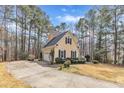 Side view of yellow two-story home with black shutters and a driveway to a two car garage at 151 Bennett Pl, Clayton, NC 27527