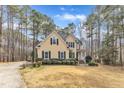 Charming yellow two-story home with black shutters and manicured landscaping surrounded by trees at 151 Bennett Pl, Clayton, NC 27527