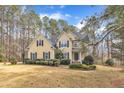 Charming yellow two-story home with black shutters and manicured landscaping surrounded by trees at 151 Bennett Pl, Clayton, NC 27527