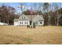 Well-maintained one-story home with a large yard, patriotic flagpole, and welcoming entryway at 203 Mitchell Manor Dr, Angier, NC 27501