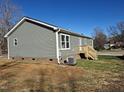 View of the back of the house showing a side entry with wood stairs and an AC unit at 209 King St, Oxford, NC 27565