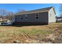 Back of the home with gray siding and multiple windows, set in a partially seeded yard at 209 King St, Oxford, NC 27565