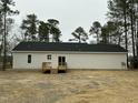 Exterior back view of the single story home, featuring a wooden deck and vinyl siding at 2242 Eldridge Rd, Newton Grove, NC 28366