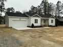 Beautiful exterior view of a single-story home with a spacious two-car garage and covered porch at 2242 Eldridge Rd, Newton Grove, NC 28366