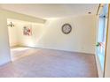 Bright living room with neutral carpet, large window, decorative clock and a view into the adjacent dining area at 2513 Boothbay Ct, Raleigh, NC 27613