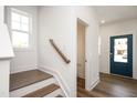 Welcoming entryway features hardwood stairs, white walls and trim, and a vibrant blue door at 301 Beacon Dr, Pittsboro, NC 27312