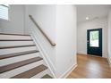 Bright staircase with white risers, wood treads, and a stained handrail leading to an upper level at 301 Beacon Dr, Pittsboro, NC 27312