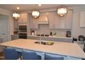 Bright and airy kitchen featuring a large island with seating and stainless steel appliances at 311 Silverhawk Ln, Durham, NC 27703