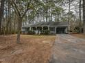 Inviting single-story house featuring a covered front porch, mature trees, and a private driveway at 314 Mill Creek Dr, Fuquay Varina, NC 27526