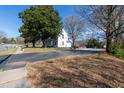 This is a house with a spacious driveway and a well-maintained lawn, framed by mature trees and a clear blue sky at 347 W Trade St, Burlington, NC 27217
