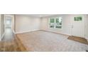 Bright living room with neutral carpet, large windows, and a welcoming front door at 349 Tristen Ln, Henderson, NC 27537