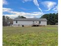 Backyard view of the home showcasing gray siding and a small wooden back porch at 349 Tristen Ln, Henderson, NC 27537
