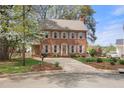 Traditional two story brick home with mature landscaping in a neighborhood setting at 3529 Elk St, Burlington, NC 27215