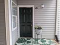 Charming entryway with a six-panel black door, leafy rug, and decorative flower pot at 3710 Pardue Woods Pl # 103, Raleigh, NC 27606