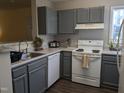 A spacious kitchen featuring sleek gray cabinets and modern white appliances at 3710 Pardue Woods Pl # 103, Raleigh, NC 27606