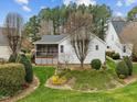 Relaxing screened-in porch overlooks well-maintained lawn and blooming greenery at 409 Latta Cir, Durham, NC 27712