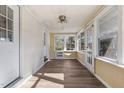 Sunroom featuring wood floors and abundant natural light, with multiple windows and access to exterior doors at 4316 Old Faison Rd, Knightdale, NC 27545