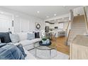 Cozy living room with a sectional sofa, glass coffee table, and a view of the kitchen and stairs at 600 Hedrick Ridge Road # 104, Cary, NC 27519