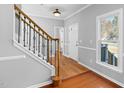 Foyer with hardwood floors, staircase with decorative wrought iron railing and large window at 604 Chadbourne Dr, Durham, NC 27703