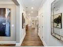 Bright hallway showcasing hardwood floors, elegant trim, and inviting views into the home at 921 Thimbleweed Way, Wake Forest, NC 27587