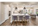 Modern open-concept kitchen with white cabinets, quartz countertops, and stainless steel appliances at 921 Thimbleweed Way, Wake Forest, NC 27587