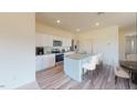 Well-lit kitchen with granite counters, stainless appliances, and an island with bar stool seating at 1128 Solace Way, Rolesville, NC 27571