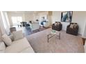 Bright, open-concept living room with modern furniture, flowing into the kitchen and dining area at 1156 Solace Way, Rolesville, NC 27571