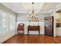 Formal dining room with hardwood floors, coffered ceiling, wainscoting, and elegant chandelier at 1209 Kingston Ridge Rd, Cary, NC 27511
