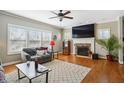 Cozy living room features a stone fireplace, hardwood floors, and multiple windows for ample natural light at 1209 Kingston Ridge Rd, Cary, NC 27511