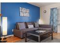 Cozy living room featuring a comfortable sofa, a modern coffee table, and a blue accent wall at 124 Friar Ln, Carrboro, NC 27510