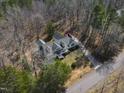 Aerial view showing home nestled in wooded area with long driveway at 180 Normandy Rd, Louisburg, NC 27549