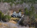 Aerial view showcases the home surrounded by lush, dense trees at 180 Normandy Rd, Louisburg, NC 27549