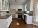 Bright kitchen featuring white cabinetry, stainless steel appliances, granite countertops and tile backsplash at 1904 Baronsmede Dr, Raleigh, NC 27615