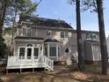 View of the back exterior showing a deck, bay window, and door leading to patio at 1904 Baronsmede Dr, Raleigh, NC 27615