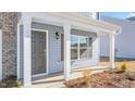 Welcoming entryway with a covered porch, featuring classic white columns and a stylish dark gray front door at 215 Leven Dr, Gibsonville, NC 27249