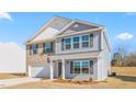 Attractive two-story home with a blend of brick and blue siding, dark shutters, and a covered front porch entry at 215 Leven Dr, Gibsonville, NC 27249