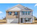 Inviting two-story home featuring brick and blue siding, complemented by dark shutters and a well-maintained front yard at 215 Leven Dr, Gibsonville, NC 27249