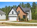 Elegant home featuring brick and siding, a two-car garage, and landscaped front yard at 230 Sutherland Dr, Franklinton, NC 27525