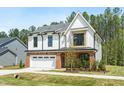 Two-story home with white facade, black trim, two-car garage, and green lawn at 240 Sutherland Dr, Franklinton, NC 27525