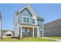 Charming two-story home featuring blue siding, brick accents, and a well-manicured lawn at 269 Marvel Dr # 138, Rolesville, NC 27571