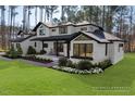 Beautiful two-story home with white painted brick, black accents, and professionally landscaped front yard at 38 Kingbird Ln, Chapel Hill, NC 27517