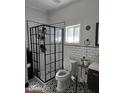 Modern bathroom featuring elegant black and white patterned tile flooring, glass shower, and stylish fixtures at 431 S Harrison Ave, Cary, NC 27511