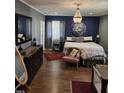 Luxurious bedroom featuring a king-sized bed, elegant chandelier, and chic decor, creating a serene retreat at 431 S Harrison Ave, Cary, NC 27511