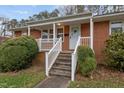 Quaint brick home featuring front porch with white picket railings at 461 Camp Rd, Burlington, NC 27217