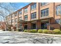 Brick condominium complex featuring a covered entrance, lush green landscaping, and ample parking space at 500 N Duke St # 53104, Durham, NC 27701